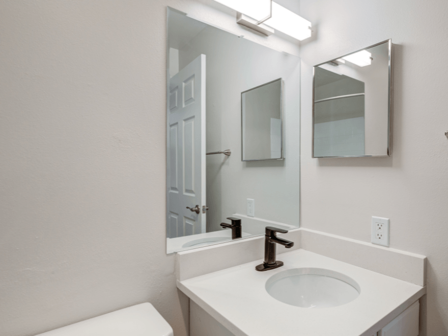 an empty bathroom with a sink and a mirror
