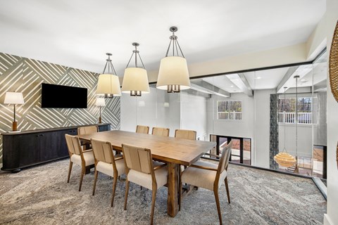 A modern dining room with a wooden table and chairs.
