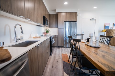 a kitchen and dining area with a wooden table and a refrigerator