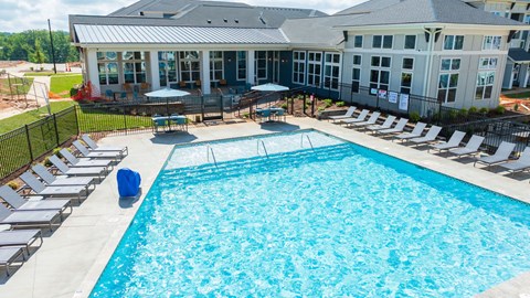a large swimming pool with a house in the background