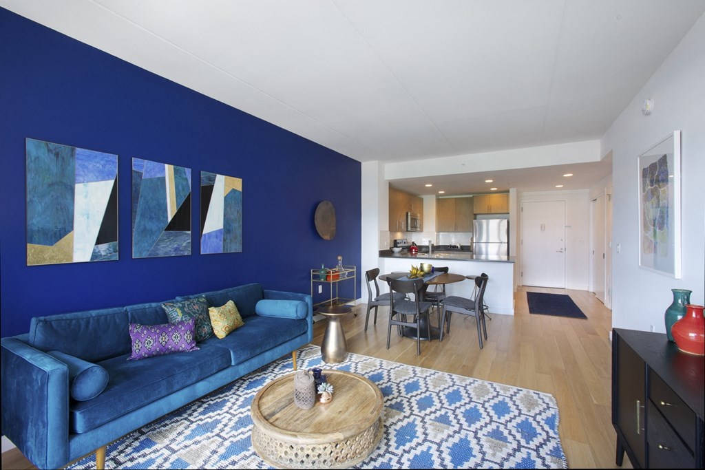 a living room with a blue accent wall and a blue couch