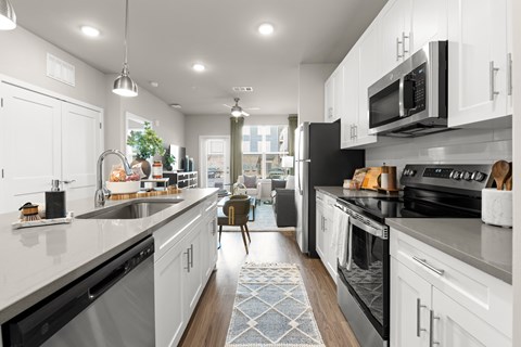 A modern kitchen with white cabinets and black appliances.