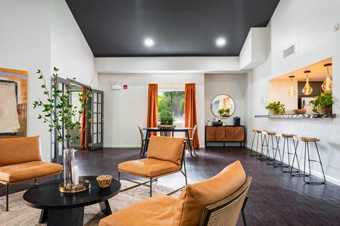 A living room with orange chairs and a black table.