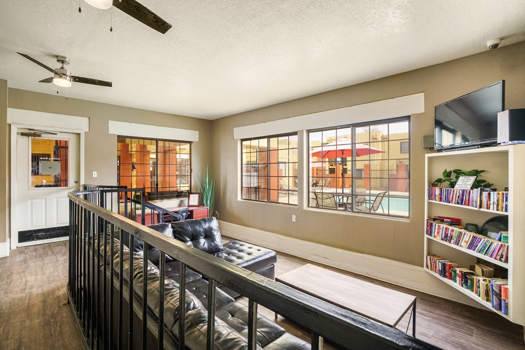 A living room with a black metal railing and a bookshelf filled with books.