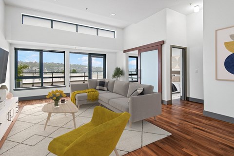 A living room with a yellow chair and a grey couch.