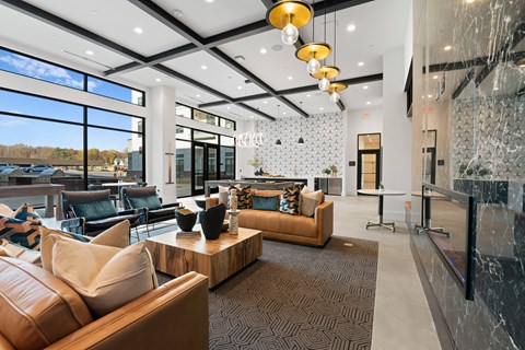 A modern living room with a brown leather couch and a wooden coffee table.