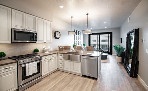 an open kitchen with stainless steel appliances and white cabinets
