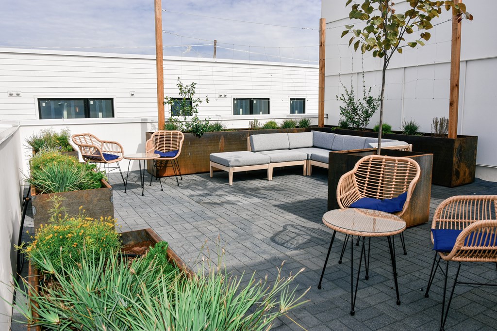 A patio with a couch, chairs, and a table.
