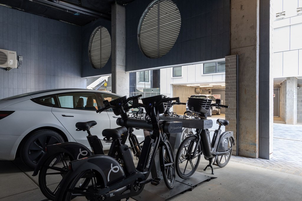 A row of bicycles are parked in a garage.
