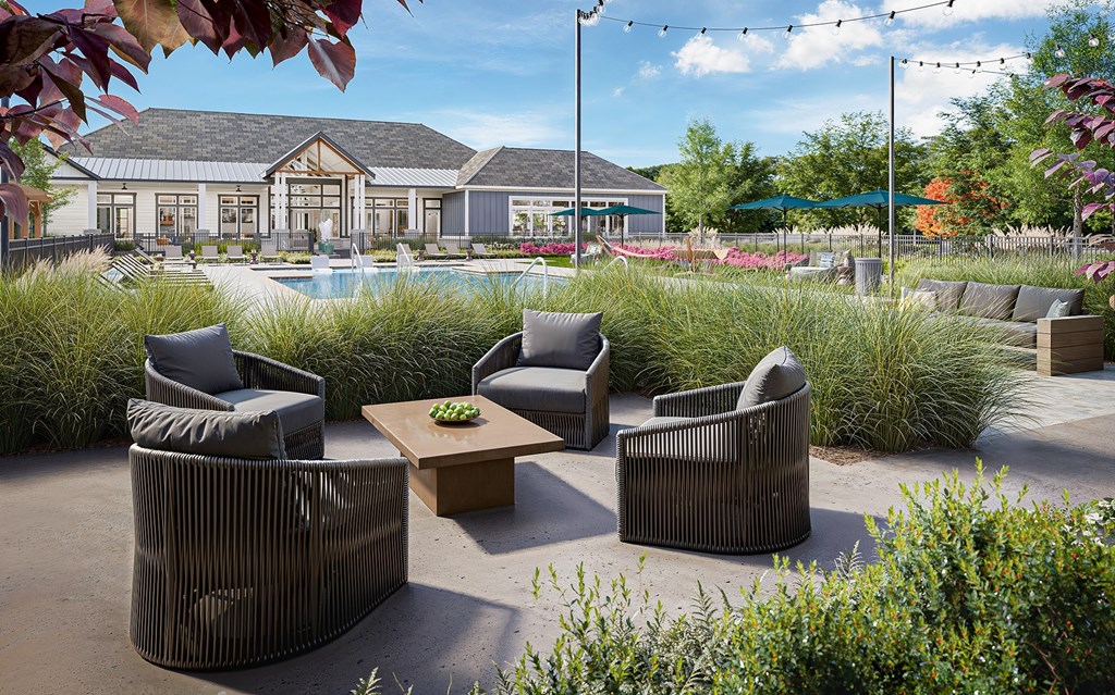 A patio with a table and chairs is surrounded by greenery at Easton at Mountain Island apartments in Charlotte, NC.