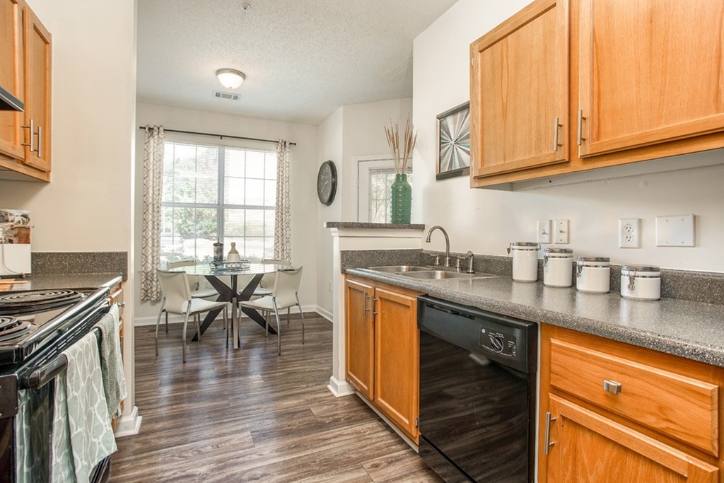 A kitchen with wooden cabinets and a black stove top oven.