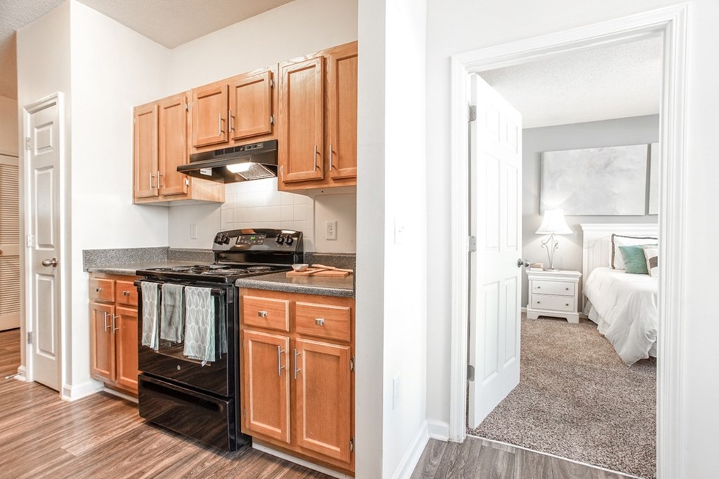 A kitchen with wooden cabinets and a black oven.
