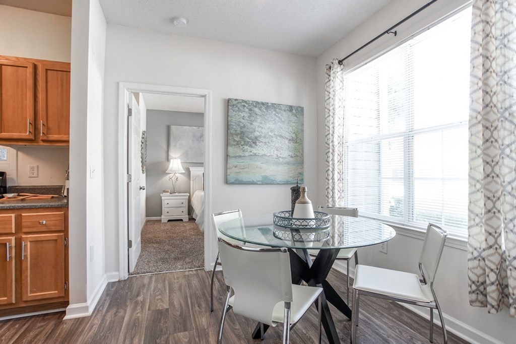 A dining room with a glass table and chairs.
