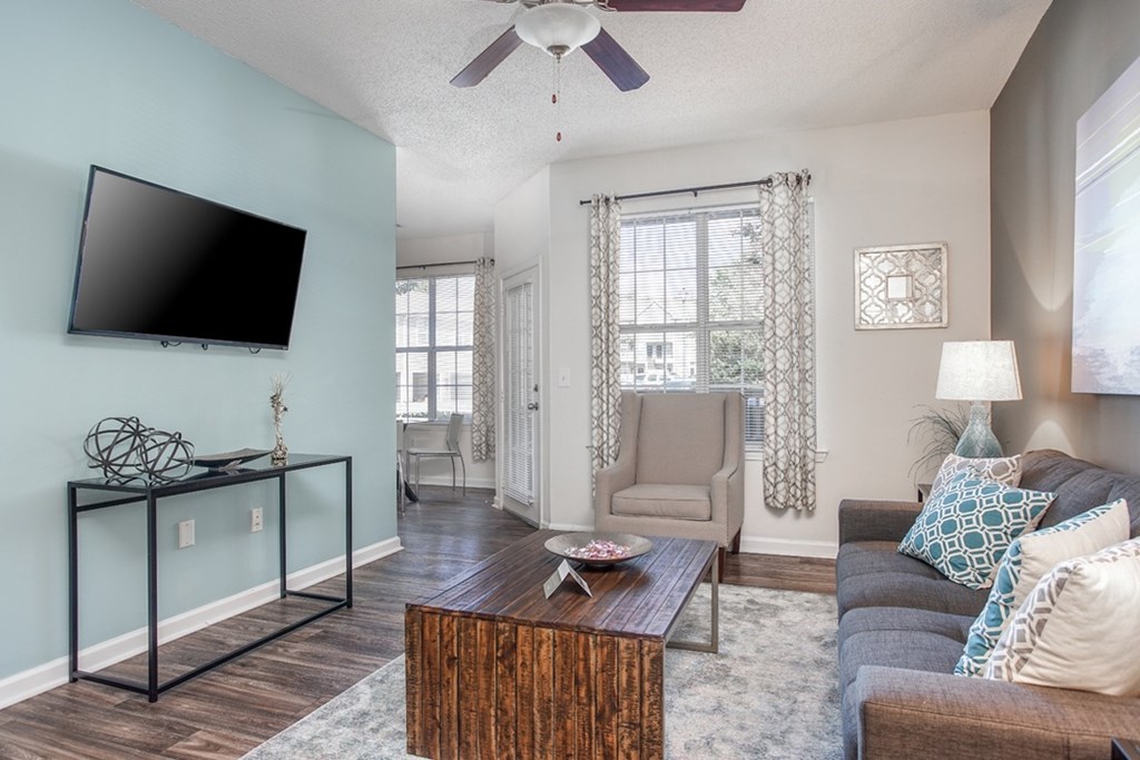 A living room with a flat screen TV mounted on the wall.