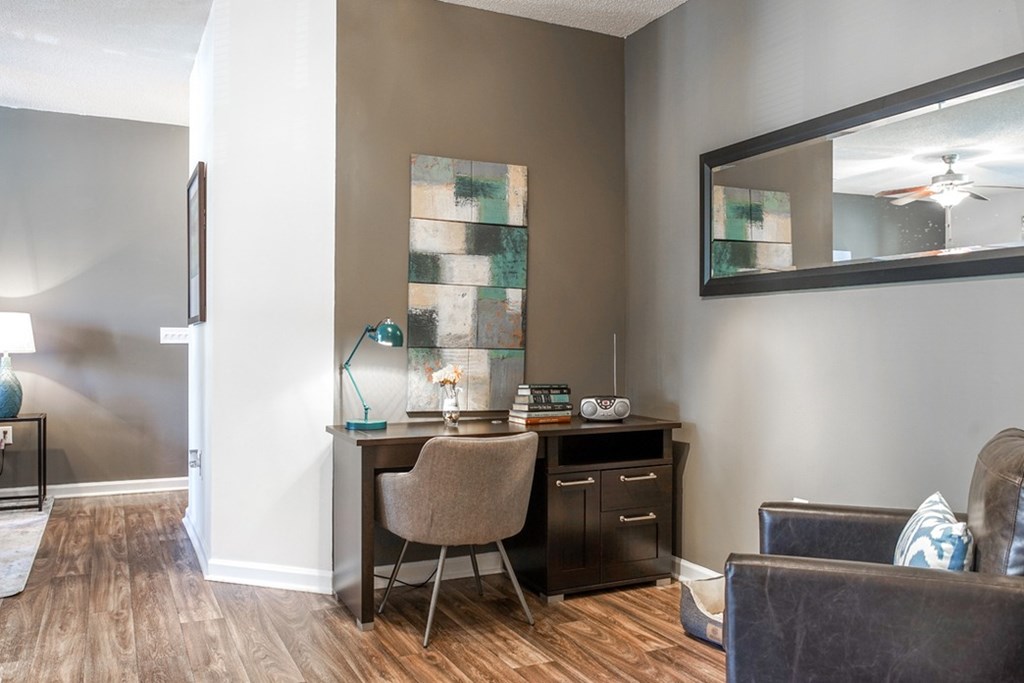 A room with a brown desk and a brown chair.