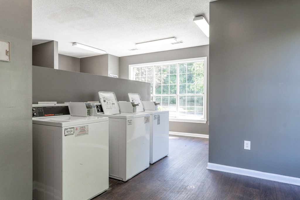 A laundry room with two washing machines and a window.