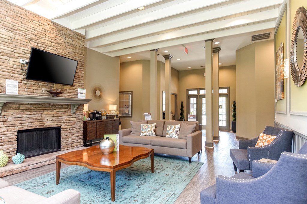 A living room with a fireplace and a flat screen TV mounted on the wall.