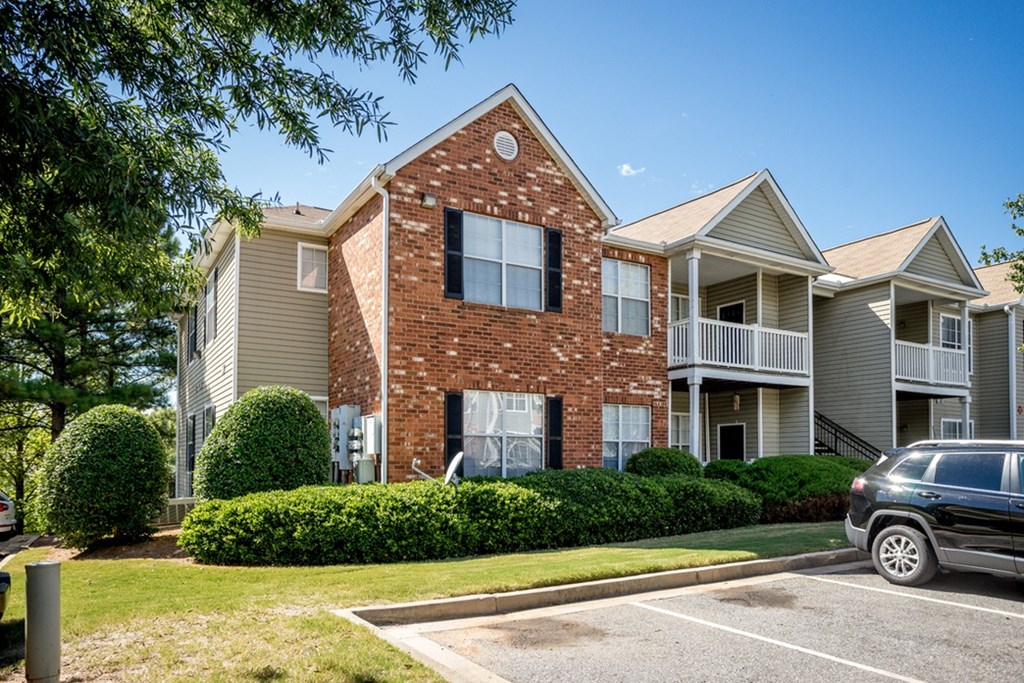 A brick house with a car parked in front.
