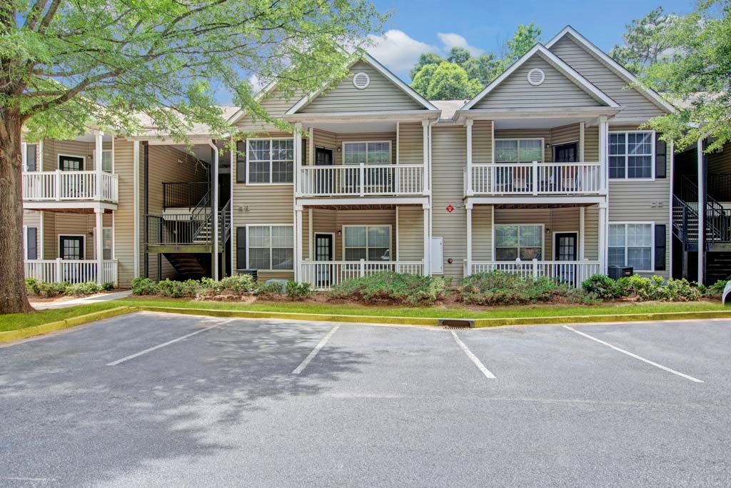 A parking lot in front of a building with a red stop sign.