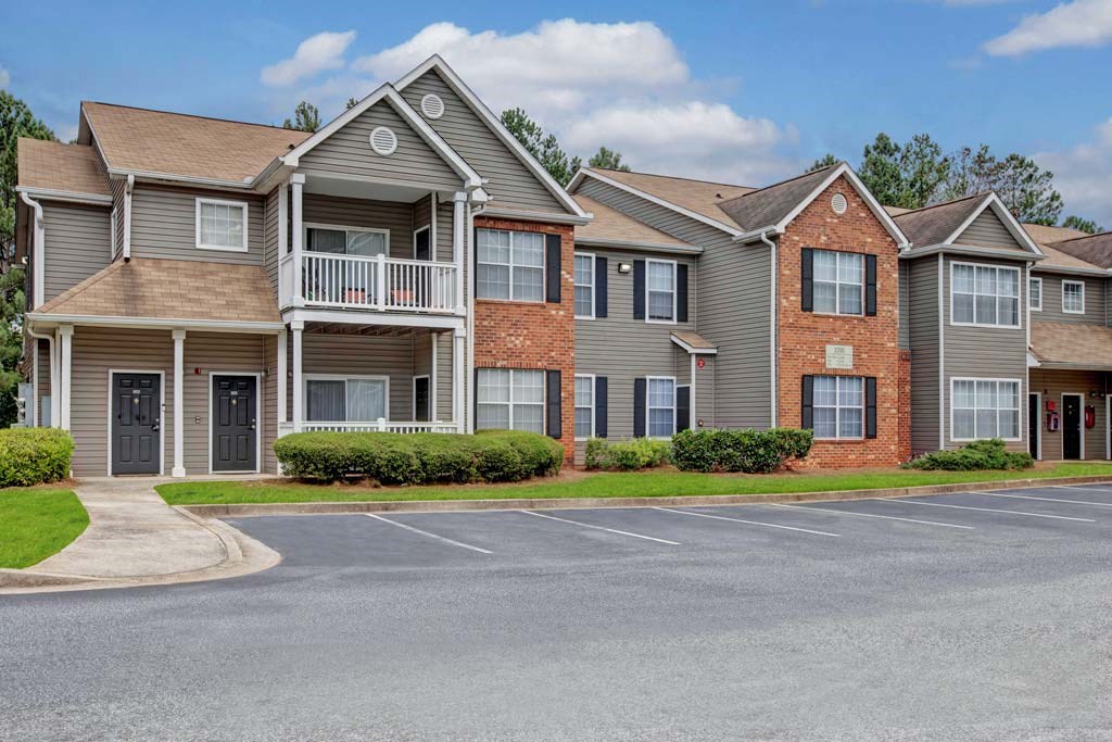 A row of houses with a paved road in front.