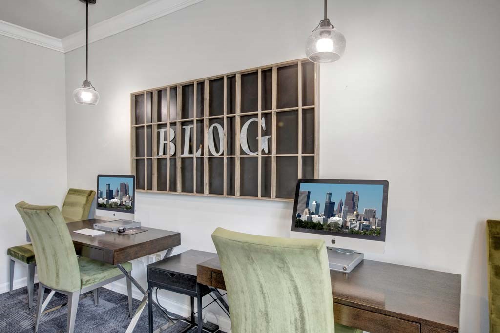A room with a desk, chairs, and a large "BLOG" sign on the wall.