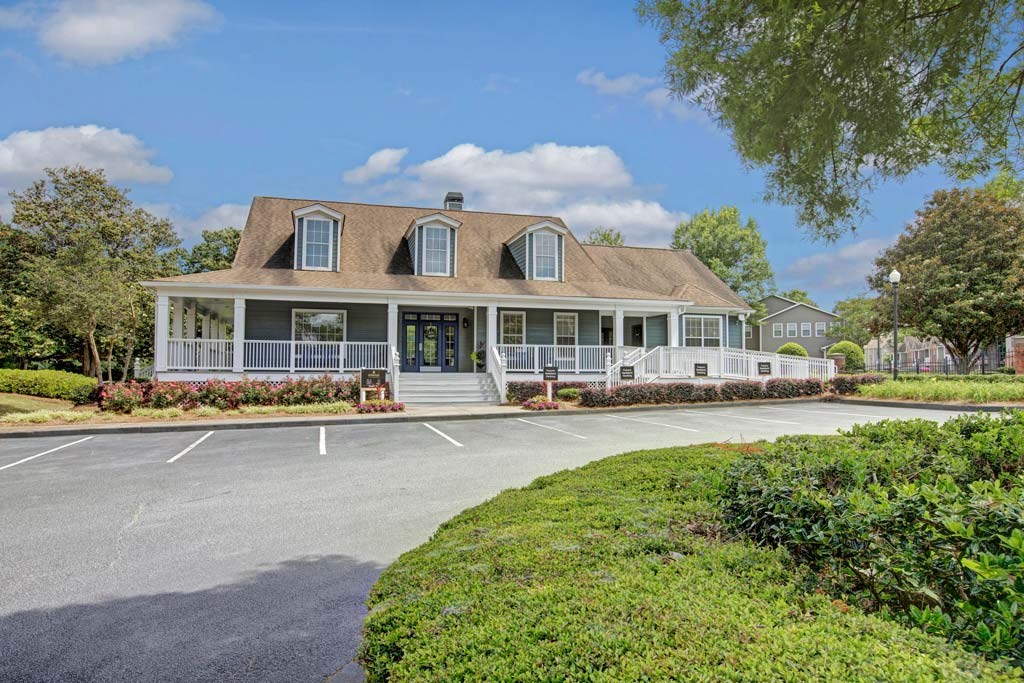A large house with a porch and a driveway in front.