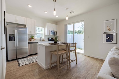 a kitchen with a center island and a stainless steel refrigerator
