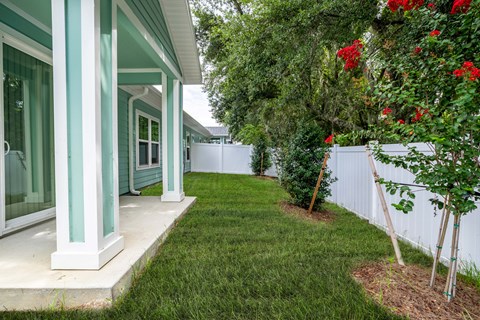 a yard in front of a house with a lawn and trees