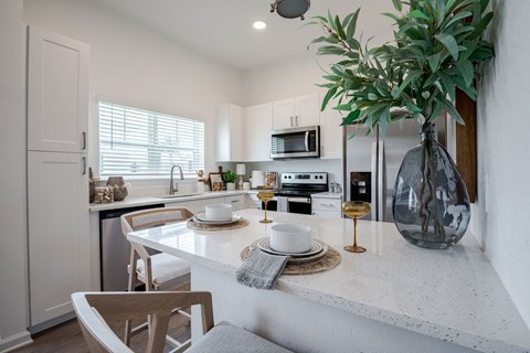 a kitchen with a white counter top and a sink