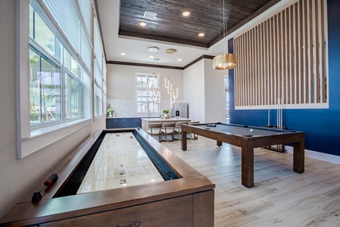 a game room with a shuffleboard table and a pool table