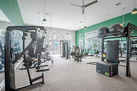 a gym with weights and other equipment in a building with green walls
