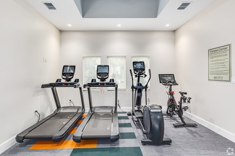 four treadmills and bikes in the gym at the monarch leasing center