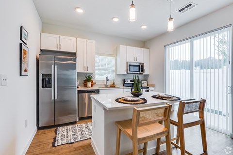 an open kitchen and dining area with stainless steel appliances and a large window