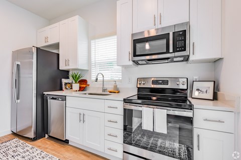 a kitchen with white cabinets and stainless steel appliances