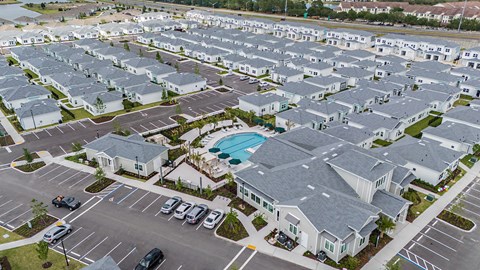 an aerial view of a parking lot filled with rows of houses