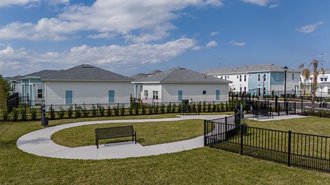 a park with a bench in front of some houses