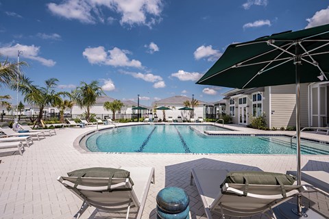 a swimming pool with lounge chairs and umbrellas at the resort