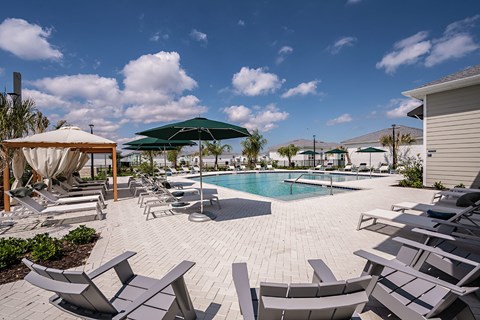 a swimming pool with lounge chairs and umbrellas at the resort