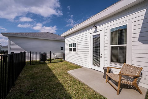 a backyard patio with a bench and a house
