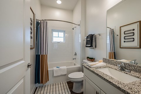 a bathroom with a shower and a sink and a toilet