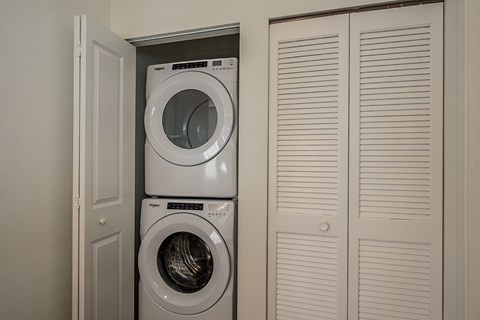 a washer and dryer in a laundry room with closet doors