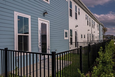 a blue house with a black fence in front of it