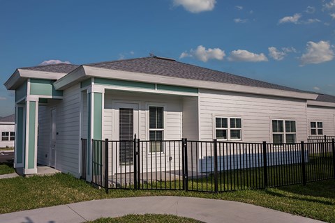 a white house with a black fence in front of it