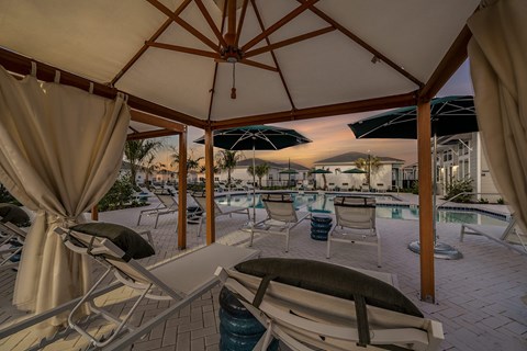 a patio with chairs and umbrellas and a pool