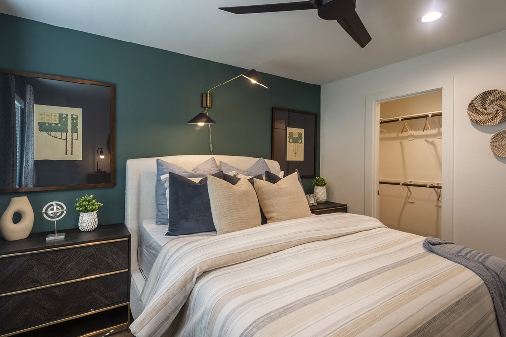 a bedroom with a large bed and a ceiling fan