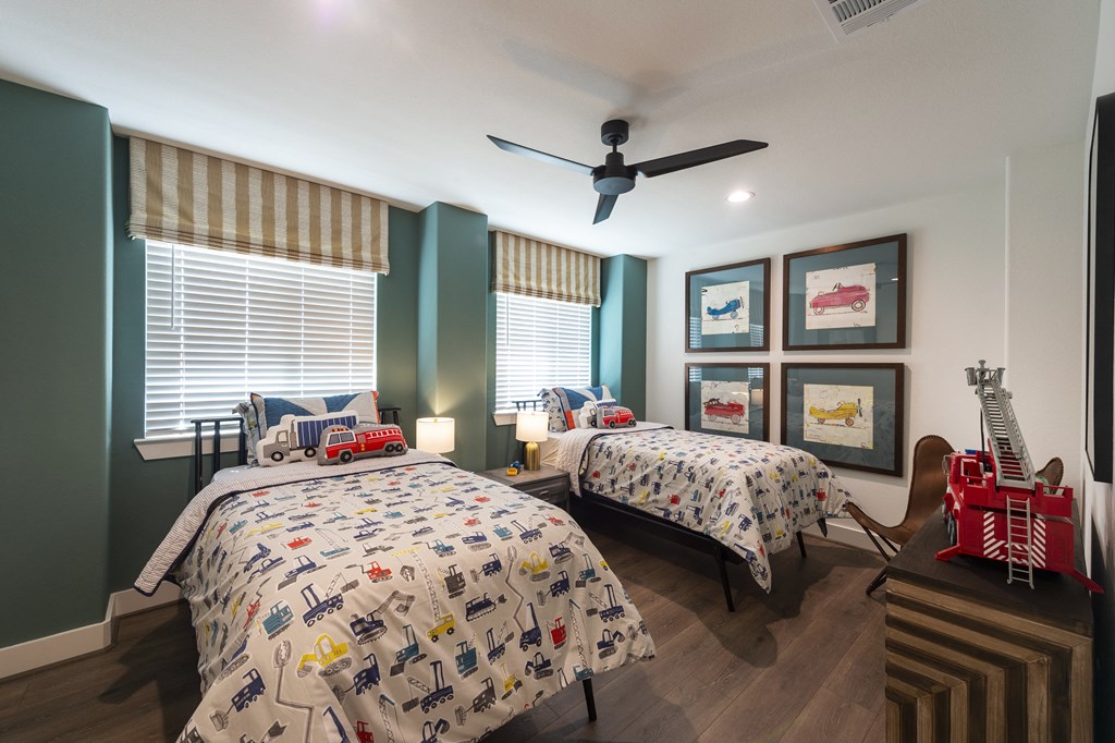 two beds in a bedroom with a ceiling fan
