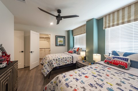 a bedroom with two beds and a ceiling fan