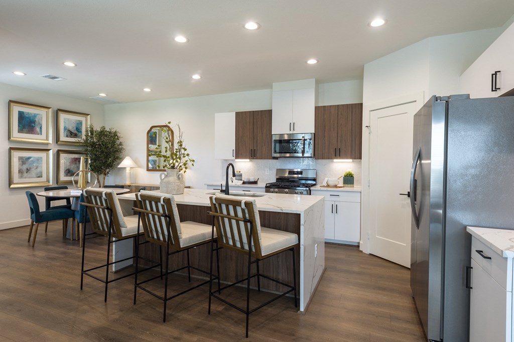 a kitchen and dining room with stainless steel appliances and a table with chairs