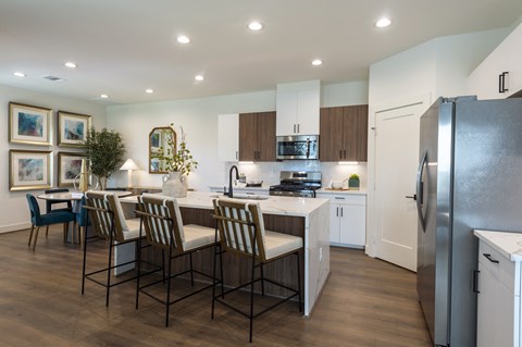 a kitchen and dining room with stainless steel appliances and a table with chairs