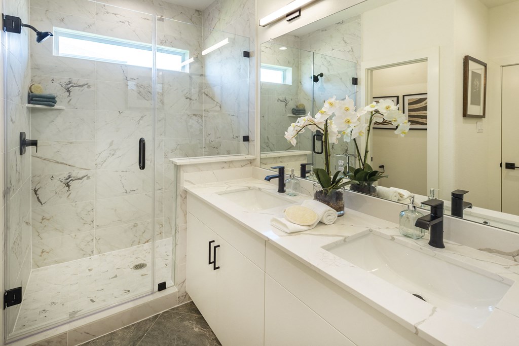 a bathroom with two sinks and a shower